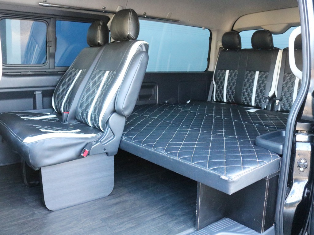 セカンドシートにもシートカバーが装着されています。足元にＦＬＥＸフッドパネル（新品）を装着して車内の高級感を高めました。３～４列目はフルフラットベッド状態で車中泊にも対応しています！
