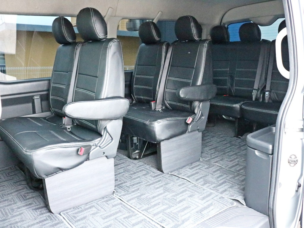 １０名定員の座席全てにレザー調シートカバー（新品）を装着しています。足元には車内の高級感を演出するインテリアフッドパネルが設置されています。